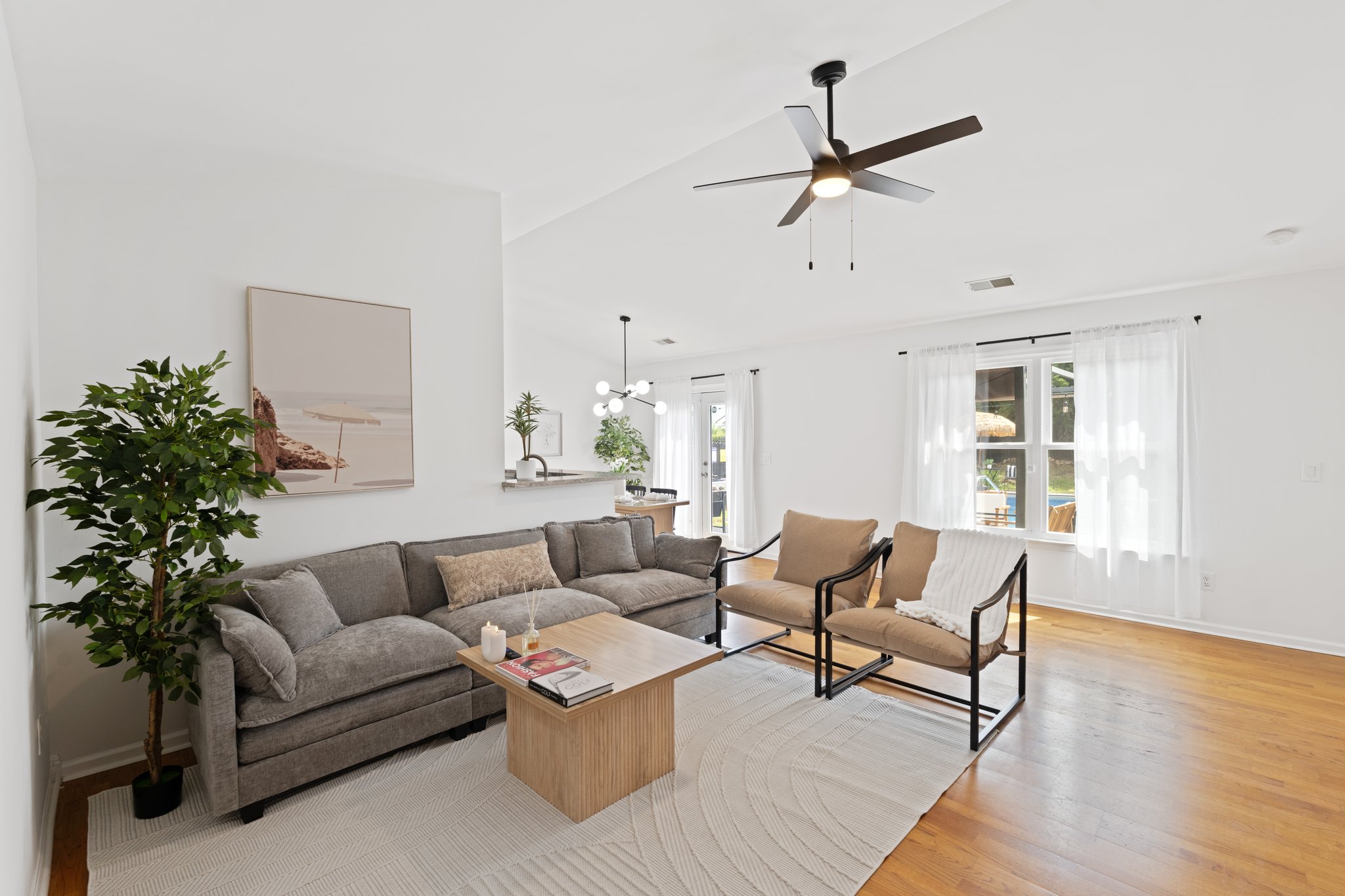 Modern living room with gray sectional sofa, wooden accents, sliding glass doors to patio, and contemporary furnishings