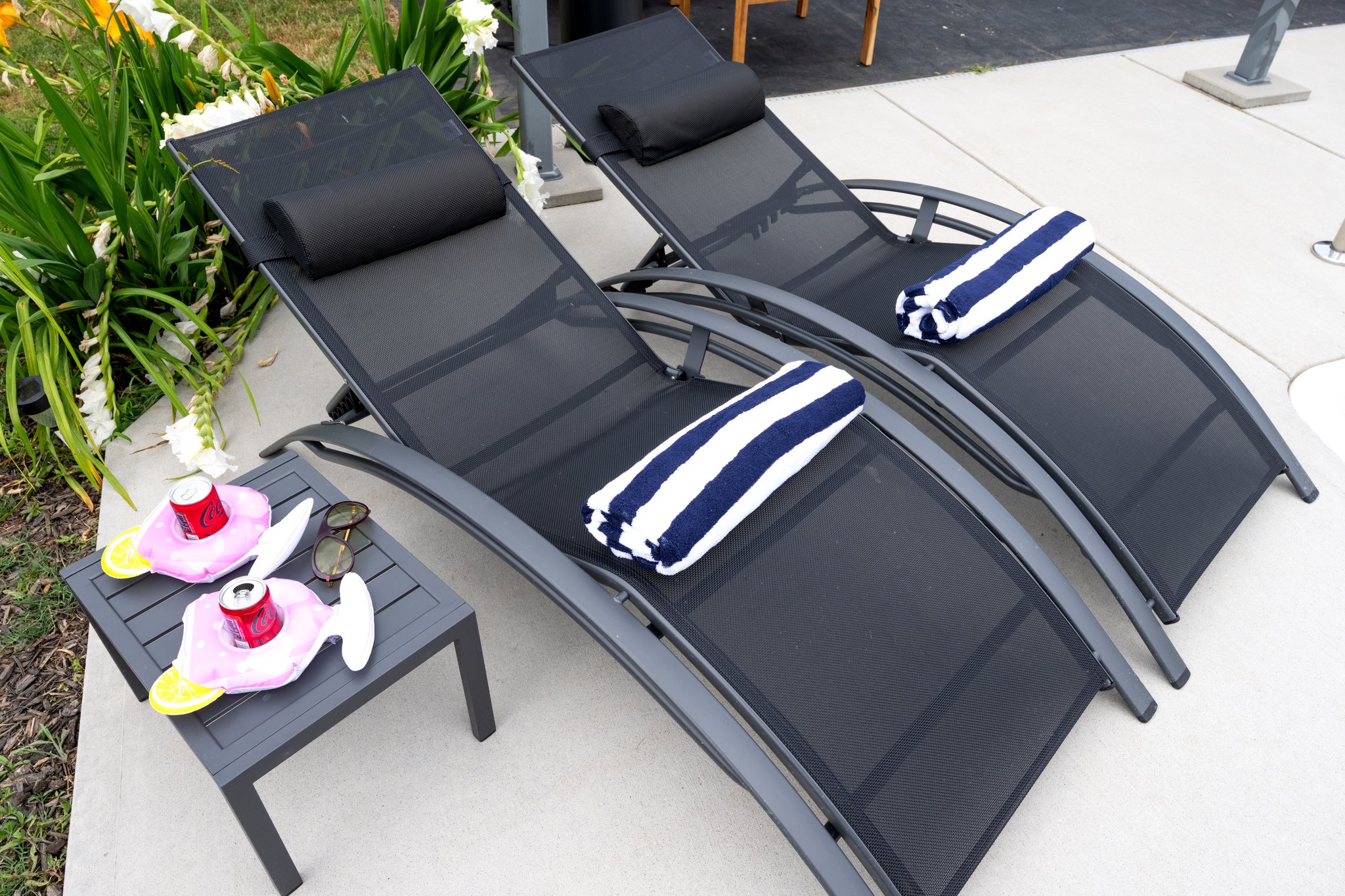 Inviting pool area with comfortable lounge seating, decorative cushions, and well-maintained landscaping